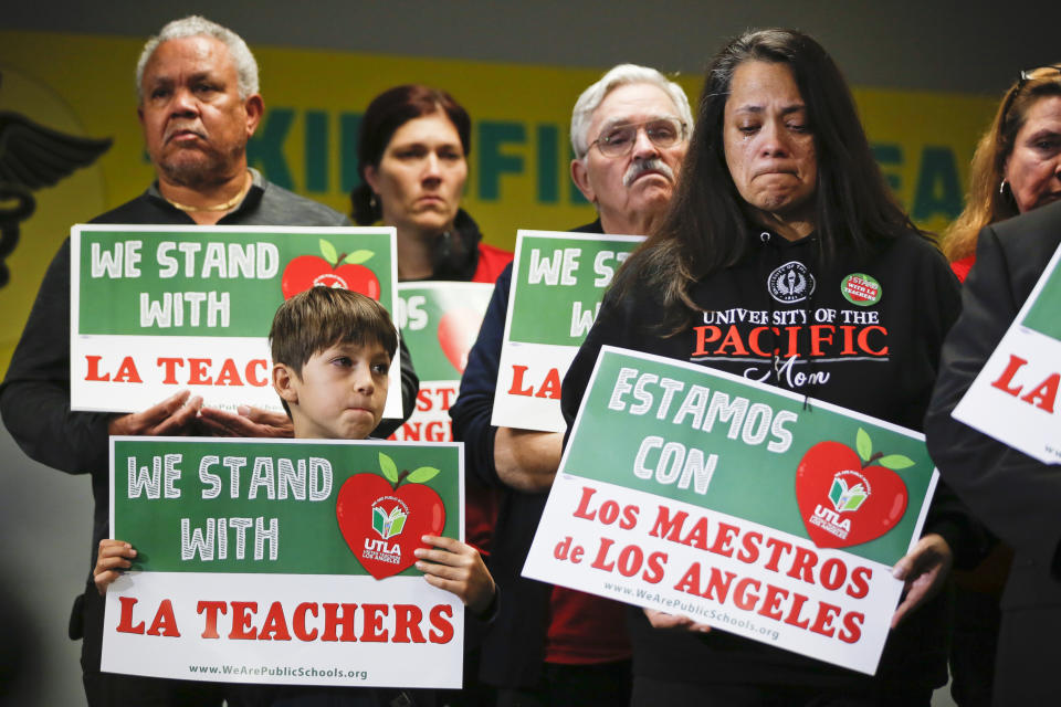 FILE - In this Jan. 13, 2019, file photo, student Leo Rittner Solomon, 6, front left, and parent Hilda Rodriguez Guzman, right, react as United Teachers Los Angeles president and teacher Alex Caputo-Pearl announces the nation's second-largest school district, Los Angeles Unified School District, was going on strike in Los Angeles. The union said Monday, Jan. 21, that teachers are due back at picket lines Tuesday morning even if an agreement is reached Monday, saying it takes time to mobilize a ratification vote of a deal. (AP Photo/Damian Dovarganes, File)