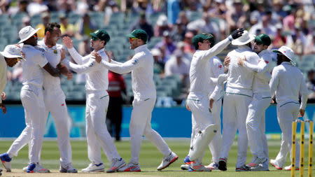 Cricket - Australia v South Africa - Third Test cricket match - Adelaide Oval, Adelaide, Australia - 25/11/16. South African players including bowler Kyle Abbott (2nd L) celebrate the dismissal of Australia's David Warner during the second day of the Third Test cricket match in Adelaide. REUTERS/Jason Reed