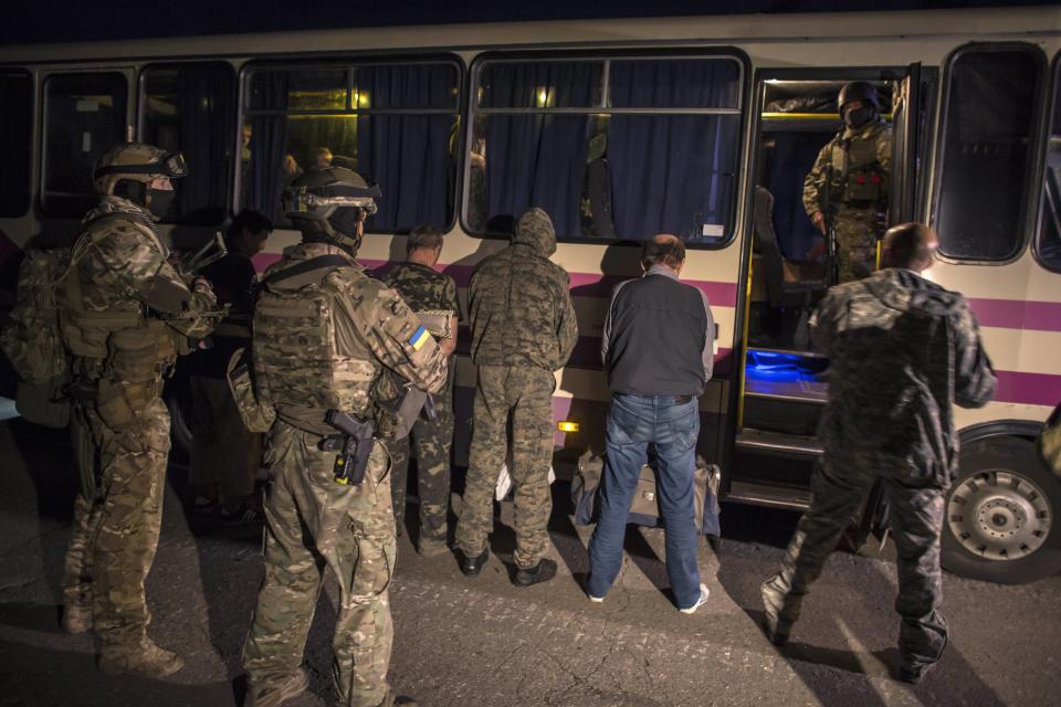 Members of the pro-Russian rebels, who are prisoners-of-war, stand in front of a bus they wait to be exchanged, north of Donetsk, eastern Ukraine