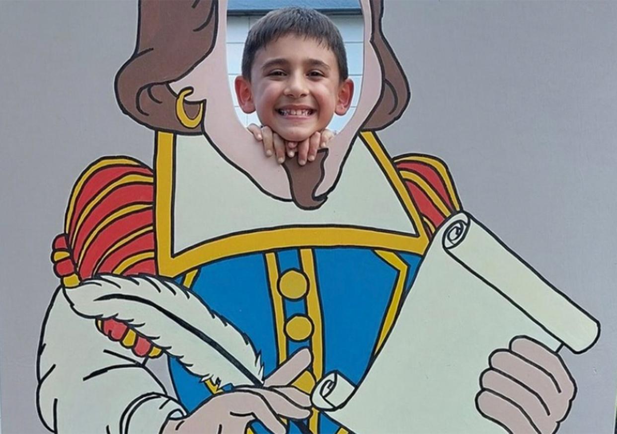 A child poses for a photo behind a cutout image of William Shakespeare at the Summer Shakesfaire festival in Athens, Ga. in 2022. The 2023 event is scheduled to take place at The Lyndon House on Saturday, Aug. 26.