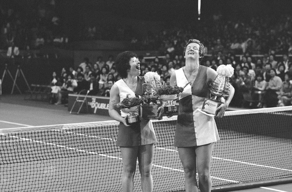 FILE - Billie Jean King of U.S., left, and Betty Stöve, of the Netherlands, are all smiles as they receive flower decorated cups and trophies after winning the $100,000 Bridgestone Women's Doubles Tournament in Tokyo, Sunday, April 25, 1976. Wednesday marks the 50th anniversary of a meeting on June 21, 1973, at the Gloucester Hotel — about a mile south of Hyde Park in the heart of the British capital — where King and nearly 60 other players agreed to form what today is known as the Women’s Tennis Association or WTA. Before what turned into a successful vote to move forward with the effort, King asked Stöve to block the conference room's exit. (AP Photo/File)