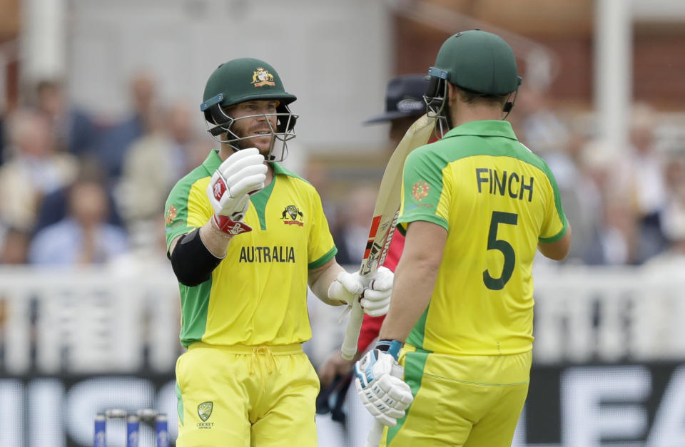 Australia's David Warner, left, celebrates reaching 50 runs with Australia's captain Aaron Finch during the Cricket World Cup match between England and Australia at Lord's cricket ground in London, Tuesday, June 25, 2019. (AP Photo/Matt Dunham)
