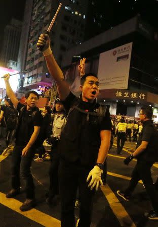 Riot policemen yell while carrying batons before charging at protesters in the Mongkok shopping district of Hong Kong early October 19, 2014. REUTERS/Bobby Yip