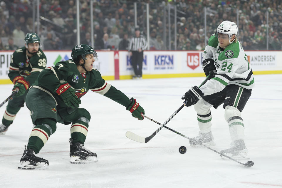 Dallas Stars center Roope Hintz, right, shoots as Minnesota Wild defenseman Brock Faber (7) defends during the first period of an NHL hockey game Monday, Jan. 8, 2024, in St. Paul, Minn. (AP Photo/Matt Krohn)