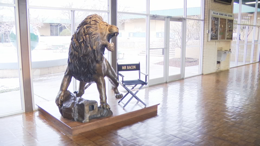 A chair designated for “Mr. Bacon” sits next to a lion statue at Payson High School. (Jeff Hunter/KTVX)