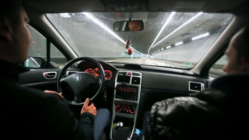 Two men in a car drive through a tunnel in Munich, Germany.