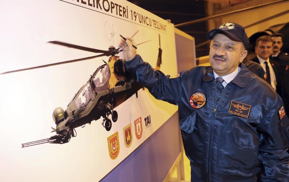 Turkey's Defense Minister Fikri Isik, wearing a helicopter pilot's jacket, speaks during a visit to a military air base in Ankara, Turkey, Wednesday, Jan. 4, 2017. Isik says a lack of support from Turkey's NATO allies in its operation to clear the Islamic State group from a town in northern Syria is leading many to question the country's permission for the U.S.-led coalition to use its air base.(AP Photo)