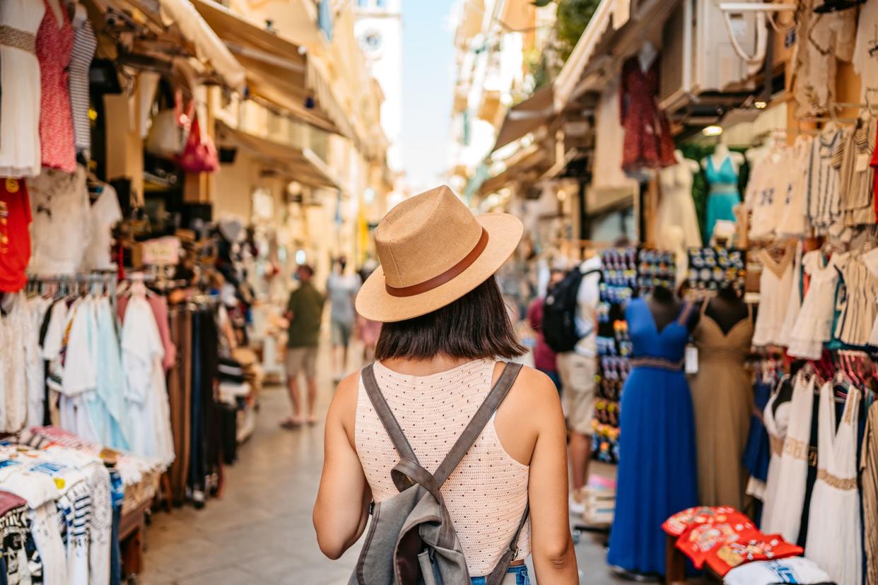 Beautiful young female tourist shopping at the street market.