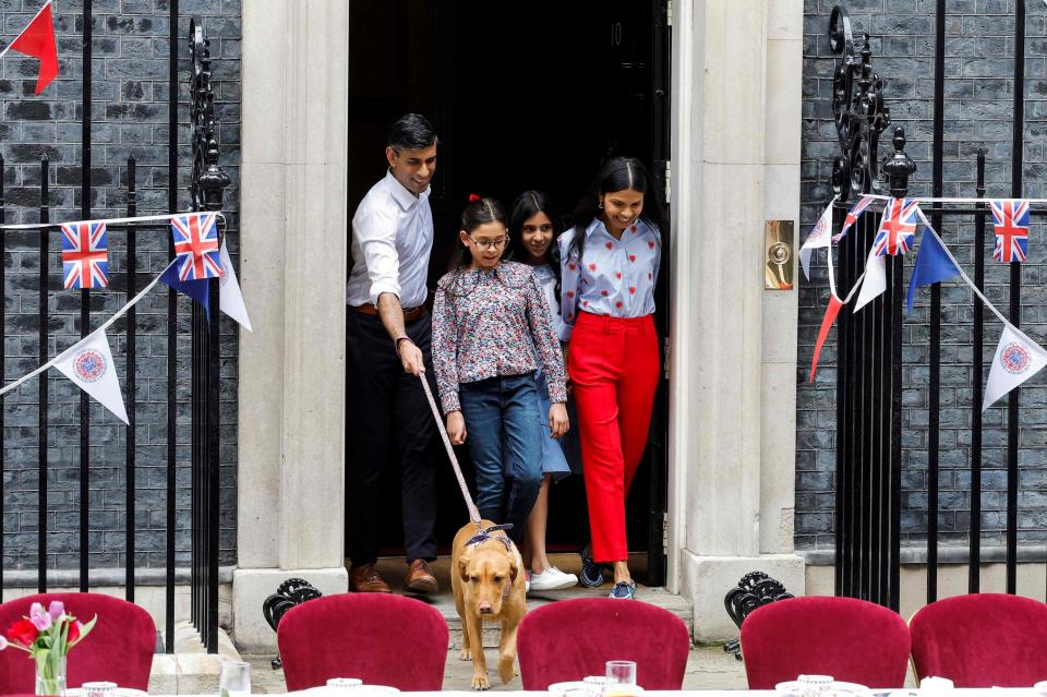 Prime Minister Rishi Sunak with his wife Akshata Murty (R), and their daughters Krishna and Anoushka Sunak arrive at a Coronation Big Lunch in Downing Street (AFP via Getty Images)