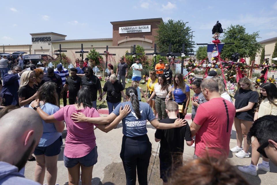 A large group of visitors are led in prayer at a makeshift memorial by the mall where several people were killed, Monday, May 8, 2023, in Allen, Texas. (AP Photo/Tony Gutierrez)