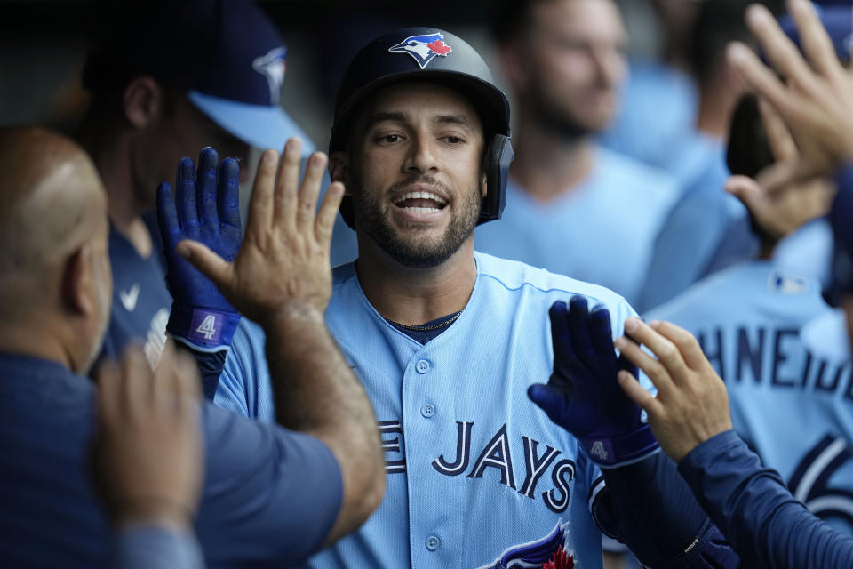 Toronto Blue Jays' George Springer celebrates in the dugout following a home run against the Cleveland Guardians during the first inning of a baseball game Wednesday, Aug. 9, 2023, in Cleveland. (AP Photo/Sue Ogrocki)