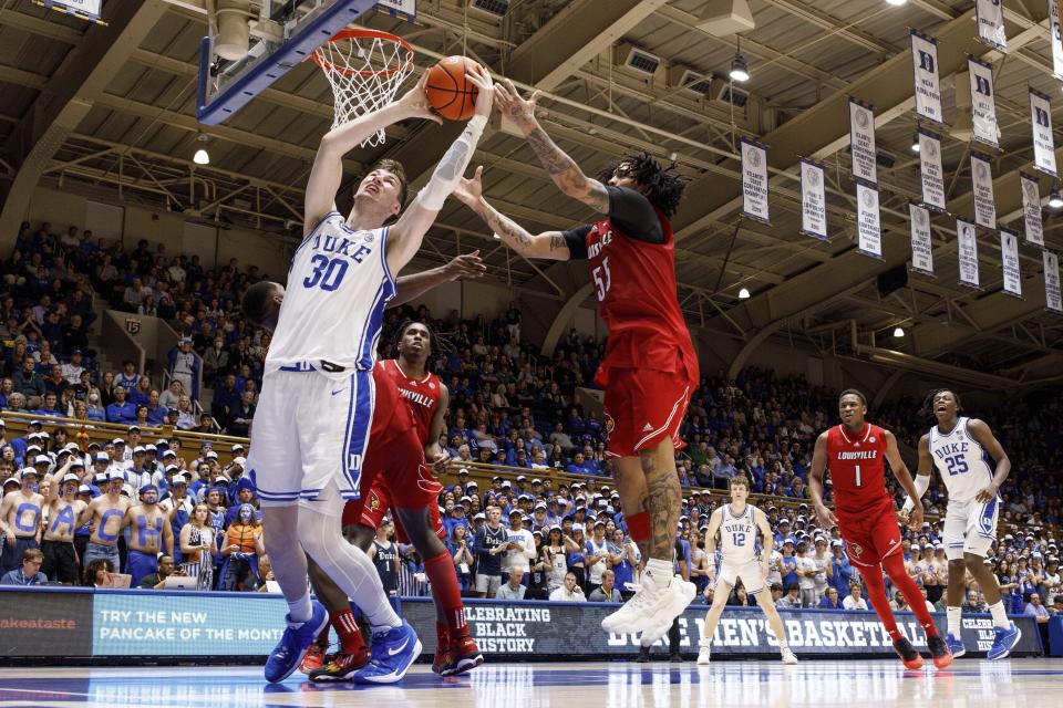 Duke's Kyle Filipowski (30) and Louisville's Skyy Clark (55) reach for a rebound during the second half of an NCAA college basketball game in Durham, N.C., Wednesday, Feb. 28, 2024. (AP Photo/Ben McKeown)