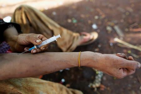 A man injects heroin into his arm along a street in Man Sam, northern Shan state, Myanmar July 11, 2016. Picture taken July 11, 2016. REUTERS/Soe Zeya Tun/Files