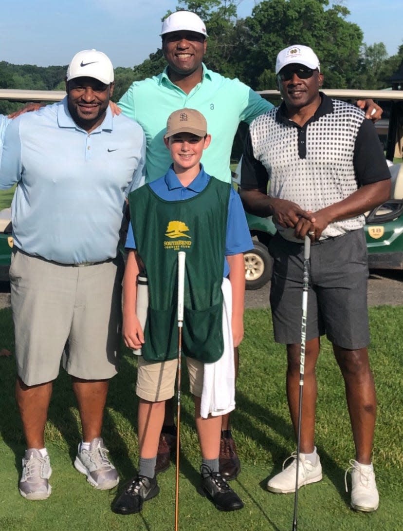 Ryan Brown, en el centro, se toma una fotografía con las leyendas de Notre Dame Jerome Bettis, izquierda, y Tim Brown, derecha, después de ser su caddie en una ronda de golf en 2019.