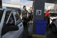 People fill their cars at a gas station in Tehran, Iran, Friday, Nov. 15, 2019. Authorities have imposed rationing and increased the prices of fuel. The decision came following months of speculations about possible rationing after the U.S. in 2018 reimposed sanctions that sent Iran's economy into free-fall following Washington withdrawal from 2015 nuclear deal between Iran and world powers. (AP Photo/Vahid Salemi)