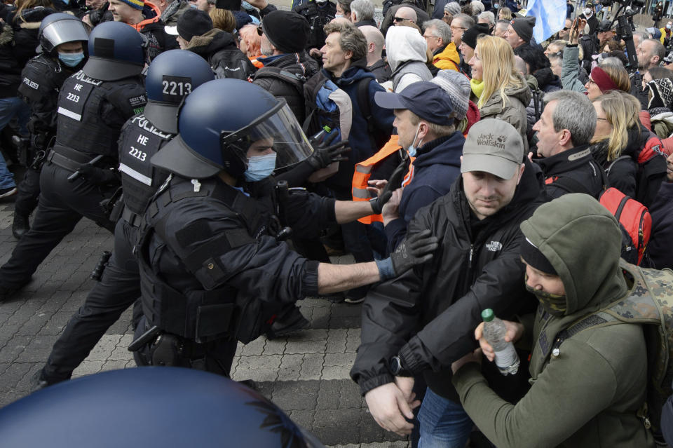 Police forces are on duty at a rally under the motto "Free citizens Kassel - basic rights and democracy" in Kassel, Germany, Saturday, March 20, 2021. According to police, several thousand people were on the move in the city center and disregarded the instructions of the authorities during the unregistered demonstration against Corona measures. (Swen Pfoertner/dpa via AP)