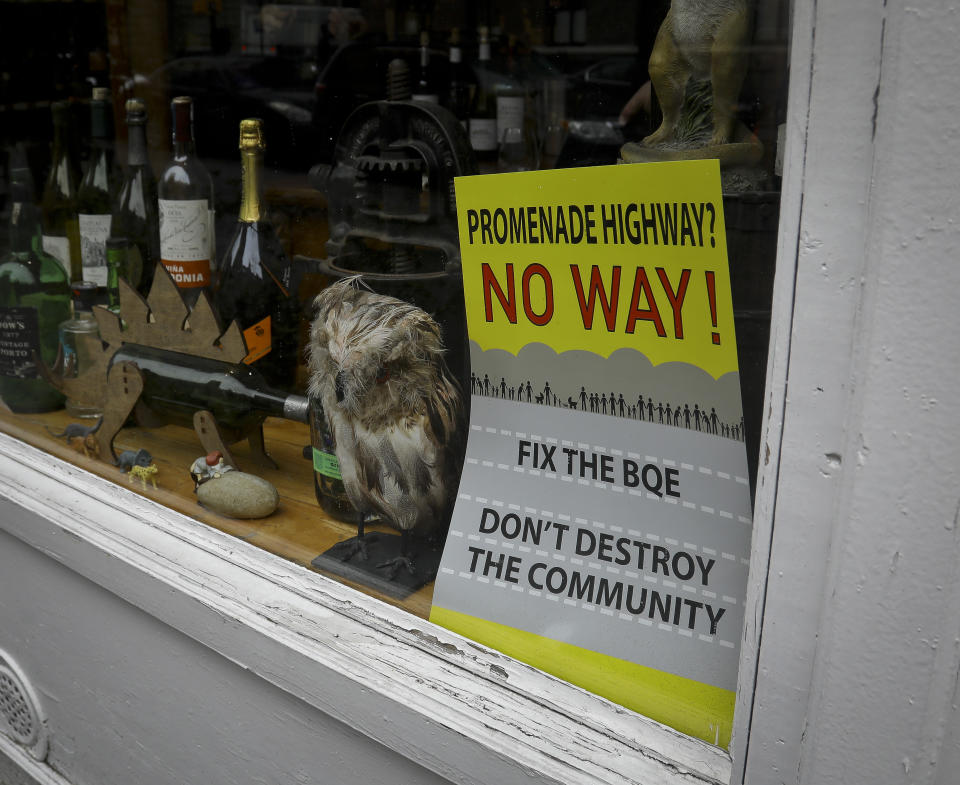 A sign in a neighborhood liquor store protest roadway repairs around Brooklyn Heights Promenade, Friday April 5, 2019, in New York. The promenade makes up the top deck overhang of a deteriorating Brooklyn-Queens Expressway and the city's plan for repairs has drawn neighborhood protest-- since it calls for a temporary six lane highway on the promenade. (AP Photo/Bebeto Matthews)