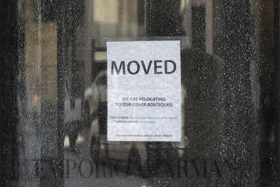 A sign is seen on a broken shop glass of Beirut Souks, a 100,000 sq. meters gigantic shopping mall, in downtown Beirut, Lebanon, Friday, Jan. 24, 2020. As cement barricades come up across the capital, blocking the path to major government buildings, Lebanese protesters vowed to continue taking to the street on the 100-day anniversary of the anti-government protests. (AP Photo/Hassan Ammar)