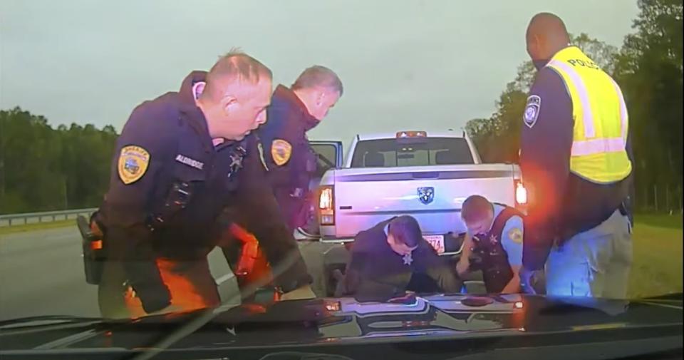 In this image taken from dash camera video provided by Camden County Sheriff's Office, law enforcement is seen administering aid to Leonard Cure, on Monday, Oct. 16, 2023, Camden County, Georgia. The sheriff of Camden County, Georgia, released body and dash camera video of a traffic stop in which a deputy fatally shot Cure, 53-year-old, after a traffic stop turned into a violent struggle. Cure previously spent 16 years imprisoned in Florida for armed robbery until authorities freed him in 2020 after reviewing his case and concluding he was wrongly convicted. (Camden County Sheriff's Office via AP)