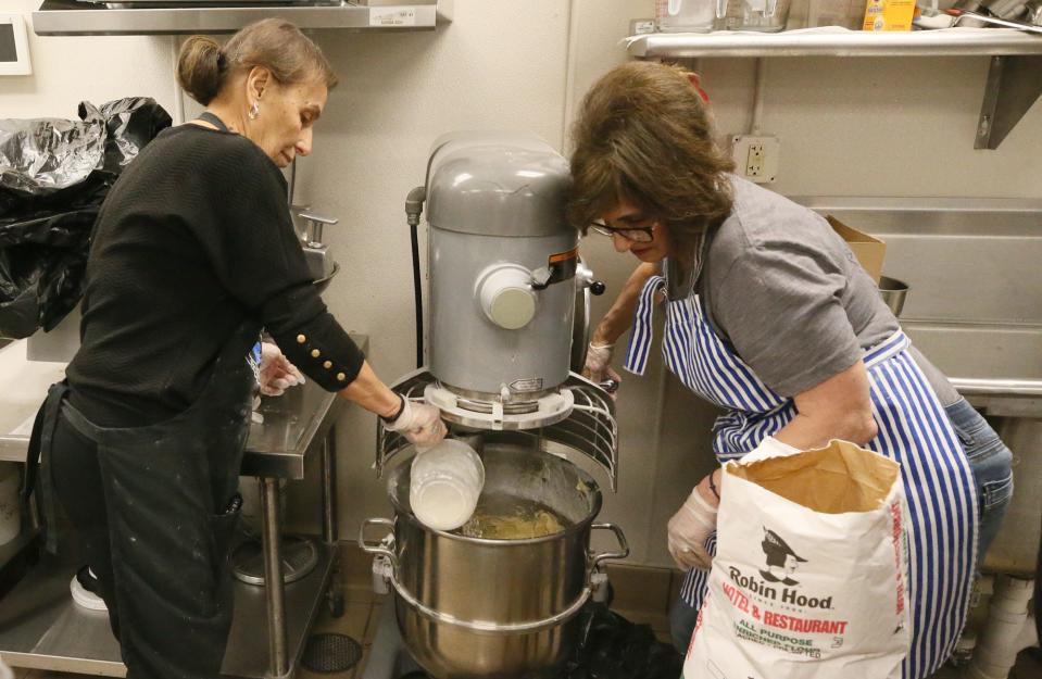 Katerina Koullias, left, and Argie Karvounides work with a mixer to make dough for tsourekia bread Tuesday. The braided Easter sweet bread will be sold at Annunciation's Easter Bake Sale March 27 and 28.