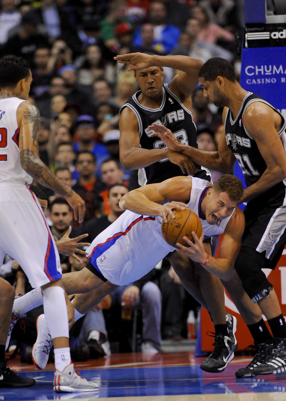 Los Angeles Clippers forward Blake Griffin, bottom middle, dives for the loose ball as San Antonio Spurs forward Boris Diaw (33), of France, and forward Tim Duncan (21) look on in the first half of a NBA basketball game, Tuesday, Feb. 18, 2014, in Los Angeles.(AP Photo/Gus Ruelas)