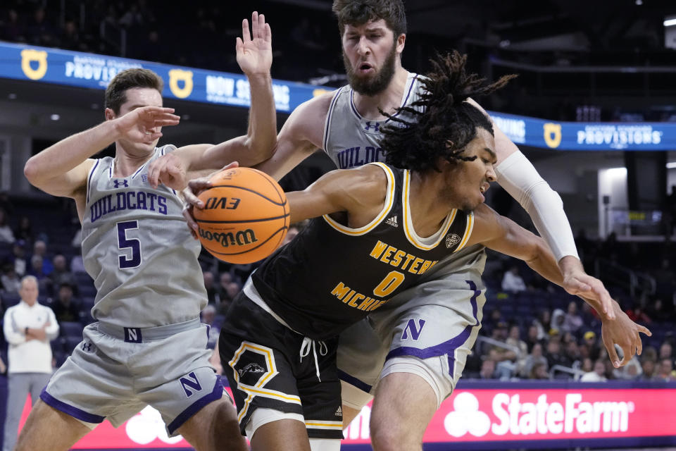 Western Michigan forward Anthony Crump (0) drives as Northwestern guard Ryan Langborg, left, and center Matthew Nicholson guard during the first half of an NCAA college basketball game in Evanston, Ill., Tuesday, Nov. 14, 2023. (AP Photo/Nam Y. Huh)