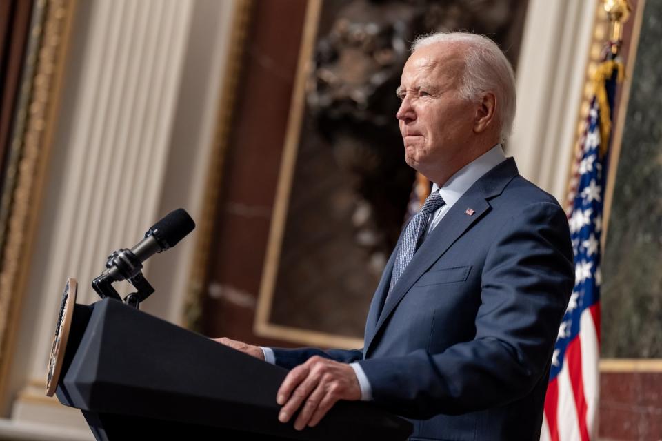 President Biden speaks to reporters from behind the presidential podium.