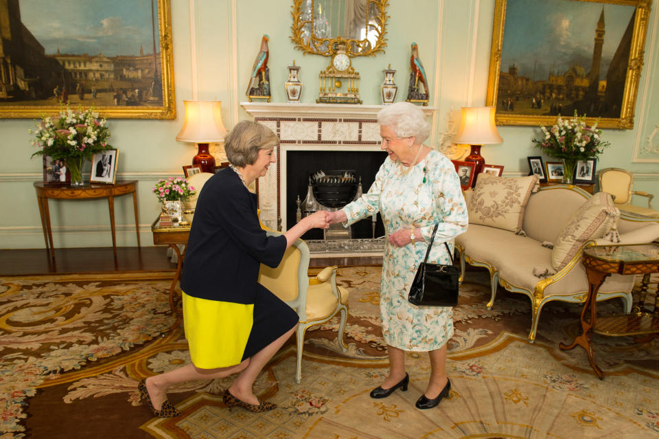 TOPSHOT - The new leader of the Conservative Party Theresa May (L) kneels as she is greeted by Britain's Queen Elizabeth II (R) at the start of an audience in Buckingham Palace in central London on July 13, 2016 where the Queen invited the former Home Secretary to become Prime Minister and form a new government. - Theresa May became Britain's second female prime minister on July 13 charged with guiding the UK out of the European Union after a deeply devisive referendum campaign ended with Britain voting to leave and David Cameron resigning. (Photo by Dominic Lipinski / POOL / AFP) (Photo by DOMINIC LIPINSKI/POOL/AFP via Getty Images)