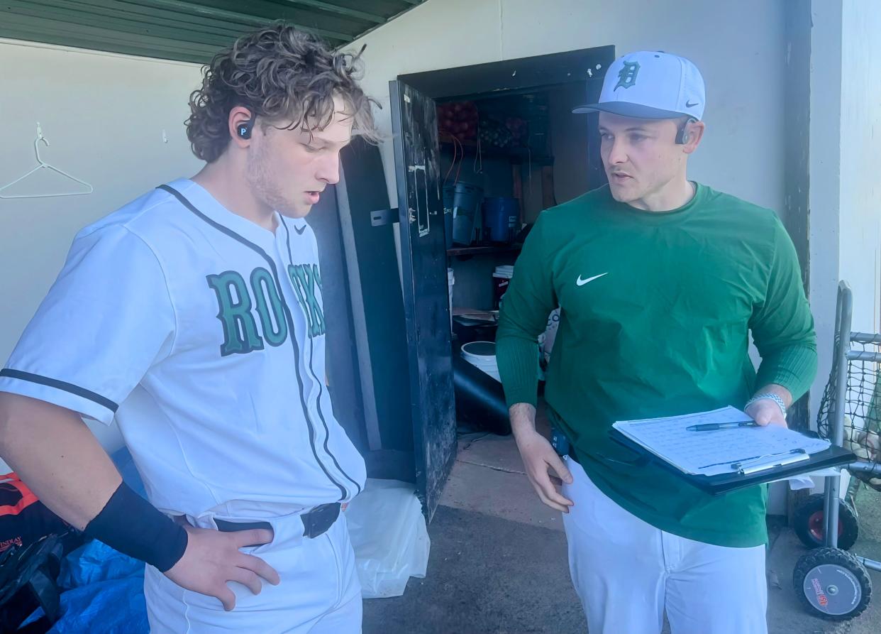 Dublin Coffman pitching coach Jameson Jacobs talks with catcher Drew Waiti during a game against Upper Arlington on April 15. Coffman is using the Porta Phone wireless communication system this spring.