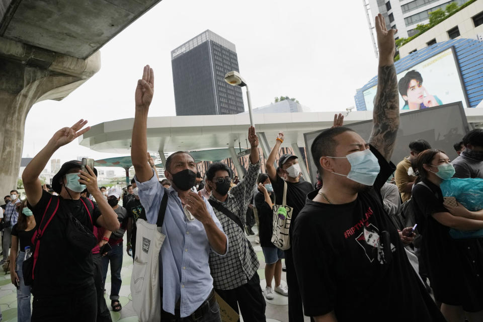 Anti-government protesters display the three-finger symbol of resistance during a protest in Bangkok, Thailand, Friday, Sept. 30, 2022. Thailand's Constitutional Court ruled Friday that Prime Minister Prayuth Chan-ocha can remain in his job and did not violate a constitutional provision limiting him to eight years in office. (AP Photo/Sakchai Lalit)