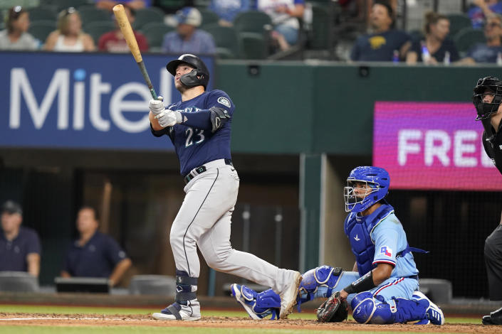 Seattle Mariners' Ty France (23) and Texas Rangers catcher Meibrys Viloria watch France's solo home run sail away during the fifth inning of a baseball game in Arlington, Texas, Sunday, July 17, 2022. (AP Photo/LM Otero)
