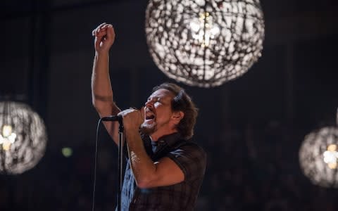 Eddie Vedder holds an arm aloft - Credit: Brian Rasic/WireImage