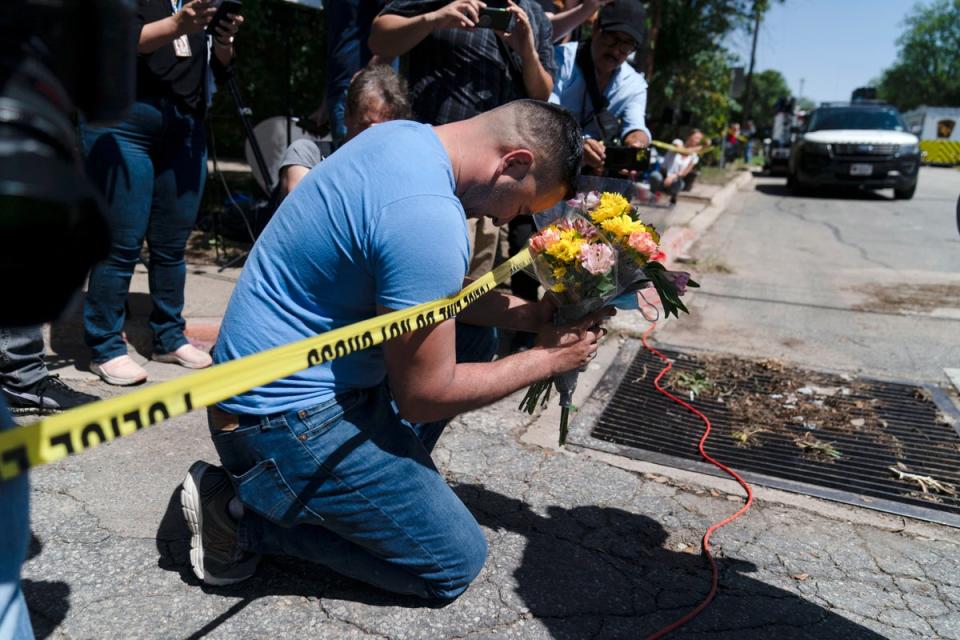 Joseph Ávila reza mientras sostiene flores en honor a las víctimas del tiroteo masivo del martes en la escuela primaria Robb en Uvalde, Texas (Jae C Hong/AP)