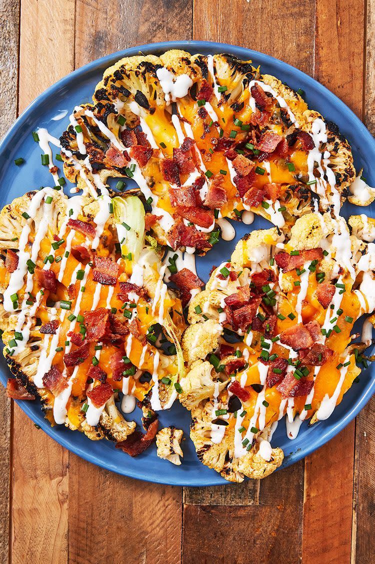 grilled cauliflower steaks with bacon and ranch on a blue plate