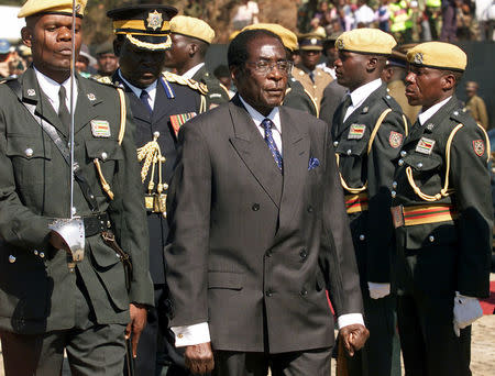 FILE PHOTO - Zimbabwe President Robert Mugabe inspects Presidential Guard troops at the annual Heroes Day commemoration of the liberation war at the Heroes Acre in the capital Harare, Zimbabwe August 11, 2003. REUTERS/Howard Burditt/File Photo