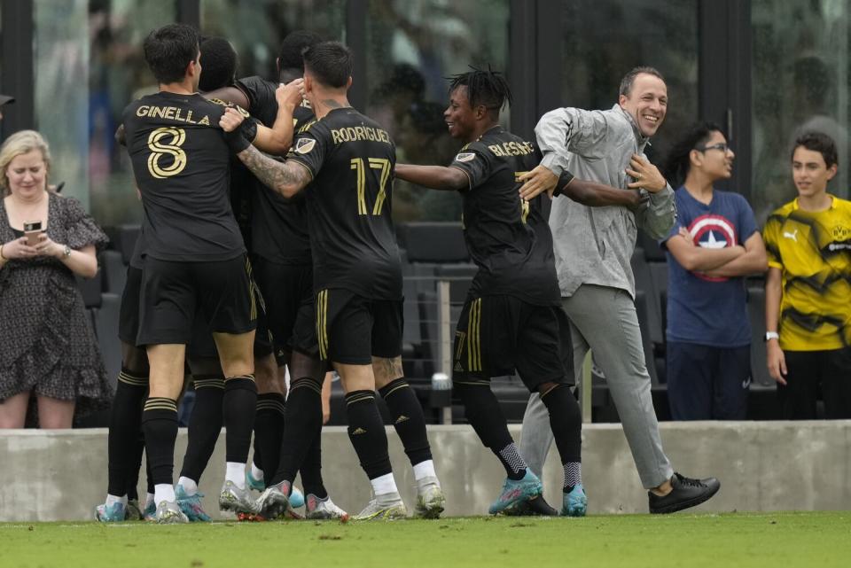 LAFC coach Steve Cherundolo congratulates players as they celebrate after scoring.