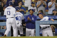 Los Angeles Dodgers' Max Muncy (13) and Mookie Betts are met at the dugout by manager Dave Roberts, center, and bench coach Bob Geren after Muncy's two-run home run during the third inning of the team's baseball game against the Arizona Diamondbacks on Tuesday, Sept. 14, 2021, in Los Angeles. (AP Photo/Marcio Jose Sanchez)