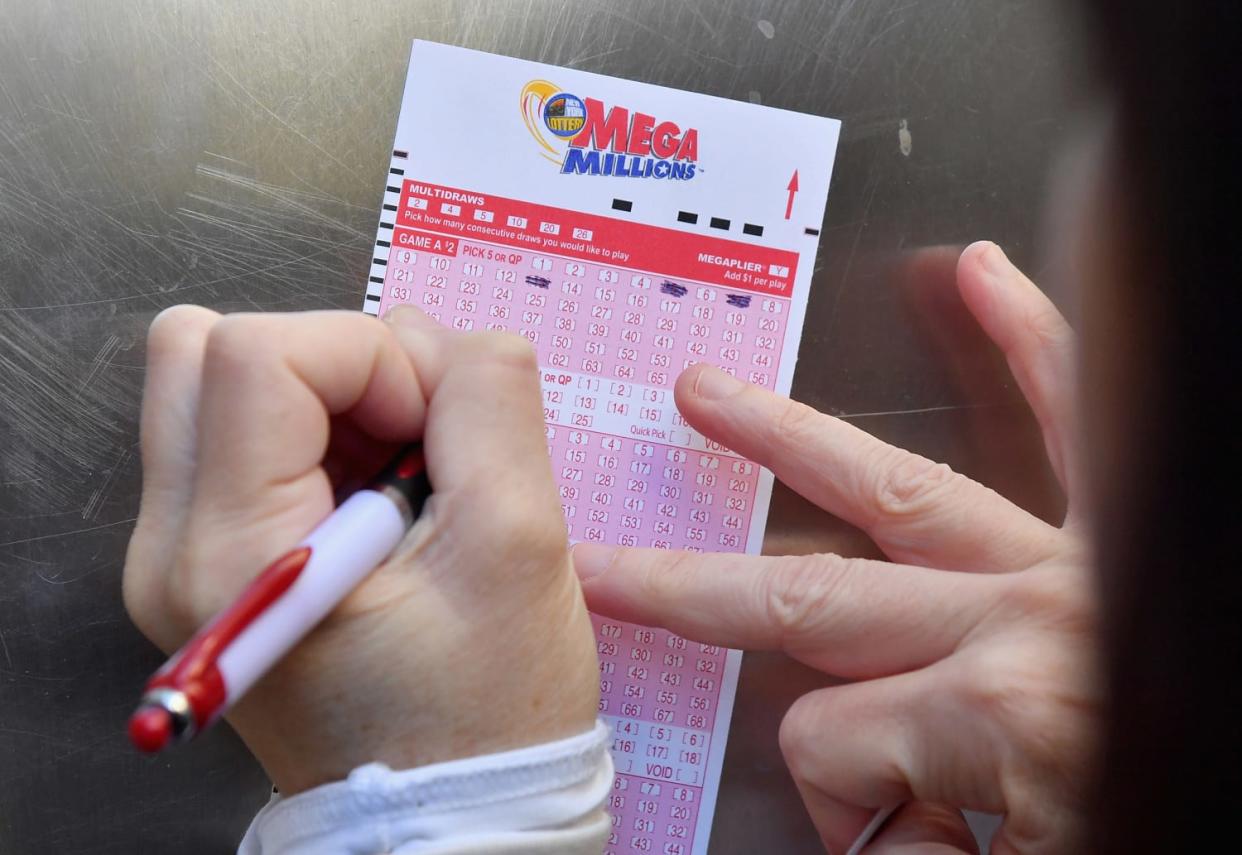 Image: A woman fills out a Mega Millions lottery ticket in New York City. (Angela Weiss / AFP via Getty Images file)