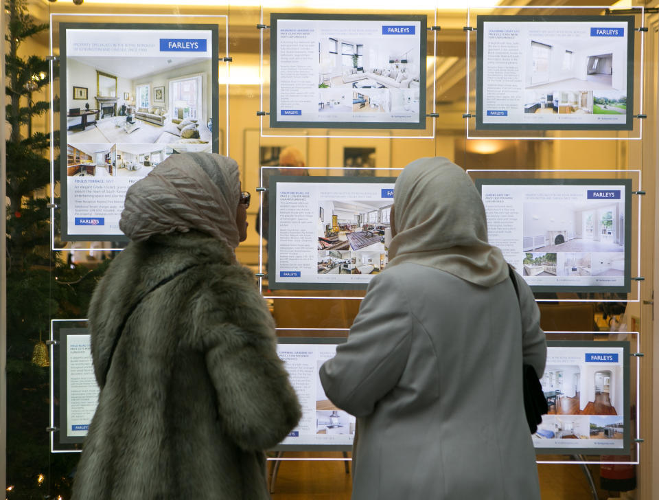 UK property: Members of the public look in the window of an estate agents in South Kensington, London