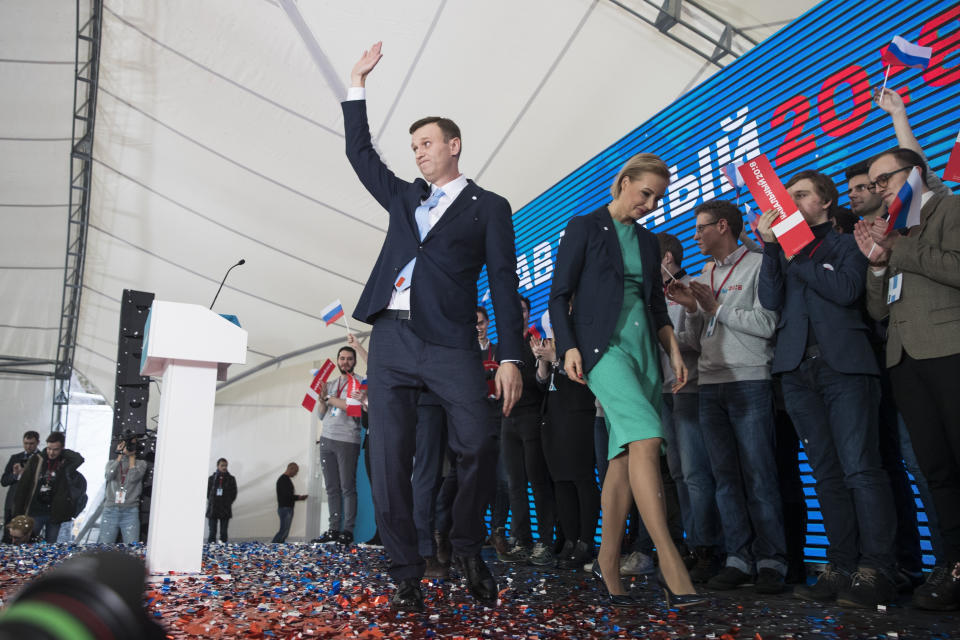 FILE - In this file photo taken on Sunday, Dec. 24, 2017, Russian opposition leader Alexei Navally, center, and his wife Yulia, center right, leave a meeting that nominated him for the presidential election race in Moscow, Russia. (AP Photo/Pavel Golovkin)