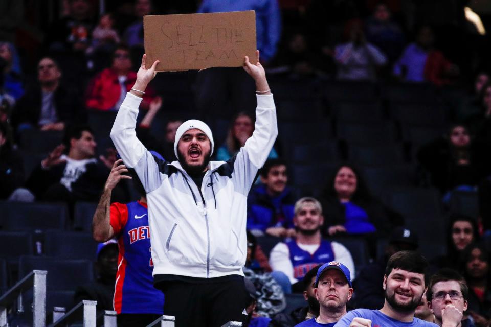 Detroit Pistons fans chant "Sell the team" and one fan holds up a sign during the second half against the Utah Jazz at Little Caesars Arena in Detroit on Thursday, Dec. 21, 2023.