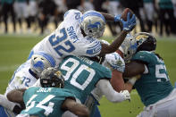 Detroit Lions running back D'Andre Swift (32) leaps over Jacksonville Jaguars linebacker Myles Jack (44) and defensive tackle Taven Bryan (90) for a touchdown during the first half of an NFL football game, Sunday, Oct. 18, 2020, in Jacksonville, Fla. (AP Photo/Phelan M. Ebenhack)