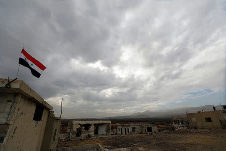 A Syrian flag is seen during an evacuation of rebels and civilians from Beit Jann, in Mogher al-Meer village, Syria December 29, 2017. REUTERS/Omar Sanadiki