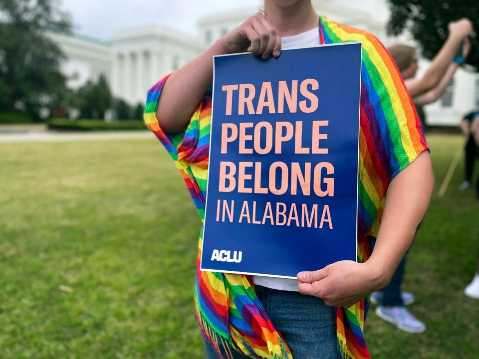 A person holds up a sign reading, "Trans People Belong in Alabama," during a rally outside the Alabama Statehouse in Montgomery, Ala., on International Transgender Day of Visibility, Friday, March 31, 2023.