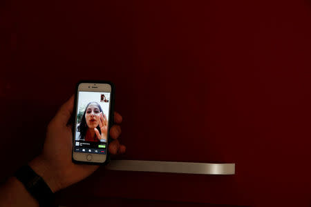 Sergio Colas communicates with his wife Alma via FaceTime so that they can read each others lips during the San Fermin festival in Pamplona, northern Spain, July 7, 2016. REUTERS/Susana Vera