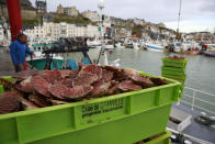 Boxes of scallops fished in the UK waters are pictured at the port of Granville, Normandy, Monday, Nov. 1, 2021. France has threatened to bar British boats from some of its ports and tighten checks on boats and trucks carrying British goods if more French vessels aren't licensed to fish in U.K. waters by Tuesday Oct.2, 2021. French fishing crews stood their ground, demanding a political solution to a local dispute that has become the latest battleground between Britain and the European Union. (AP Photo/Nicolas Garriga)