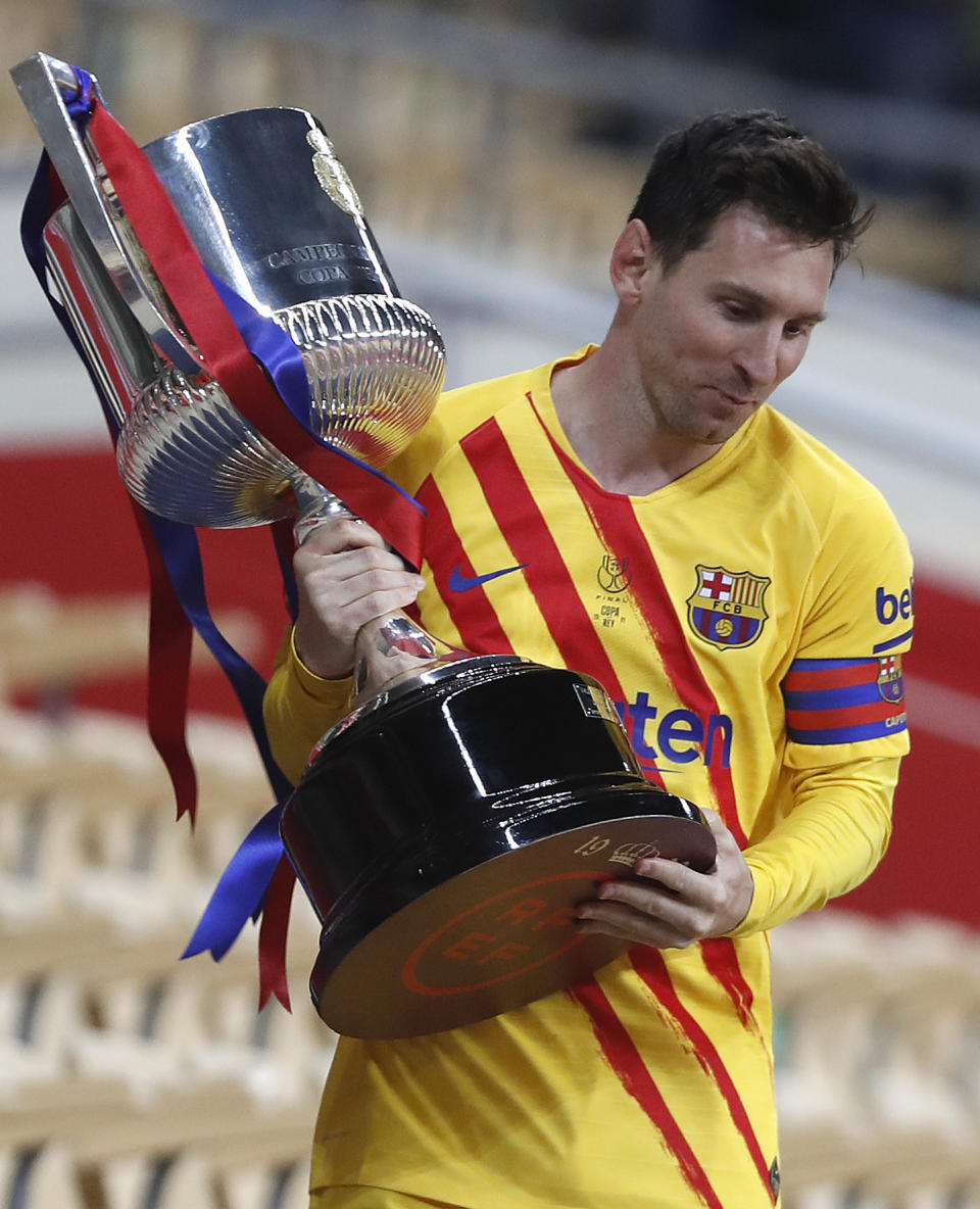 Barcelona's Lionel Messi holds the trophy after winning the Spanish Copa del Rey final 2021 against Athletic Bilbao at La Cartuja stadium in Seville, Spain, Saturday April 17, 2021. (AP Photo/Angel Fernandez)