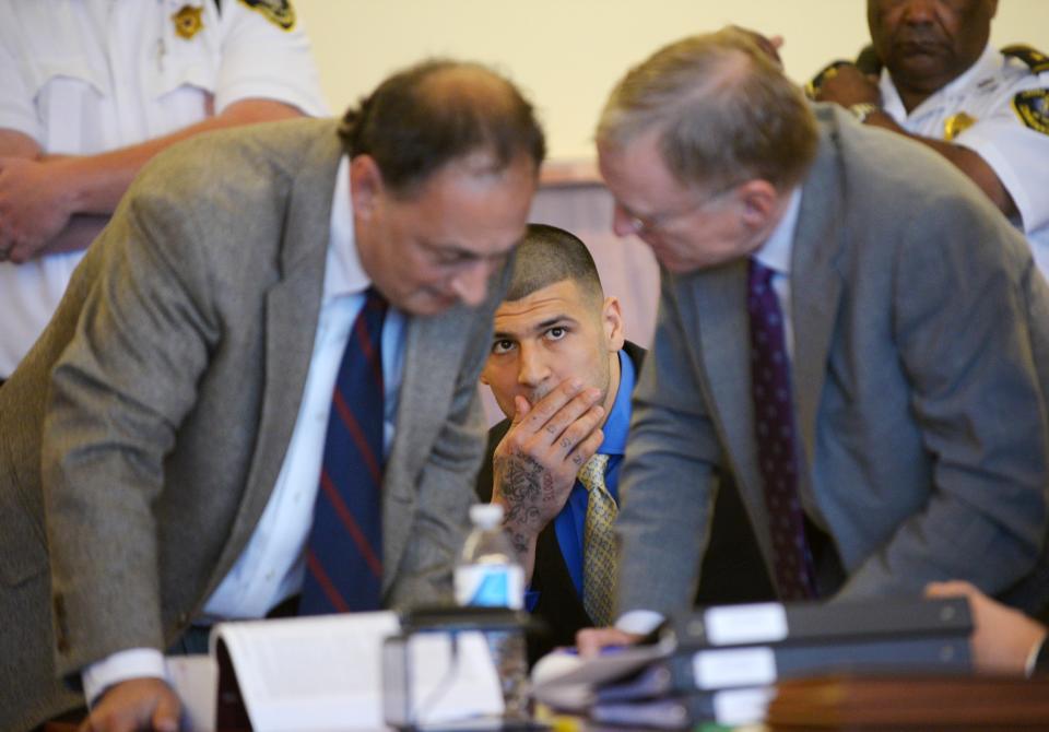 Former NFL New England Patriots football player Aaron Hernandez watches his defense attorneys, Jamie Sulton and Charles Rankin (R) talk during a hearing at the Bristol County Superior Court House in Fall River, Massachusetts, June 16, 2014. Attorneys for former NFL star Aaron Hernandez on Monday called on a judge to throw out charges that the ex-tight end murdered a semiprofessional football player in June 2013, one of three homicides Hernandez is charged with. REUTERS/Faith Ninivaggi/POOL (UNITED STATES - Tags: CRIME LAW SPORT)