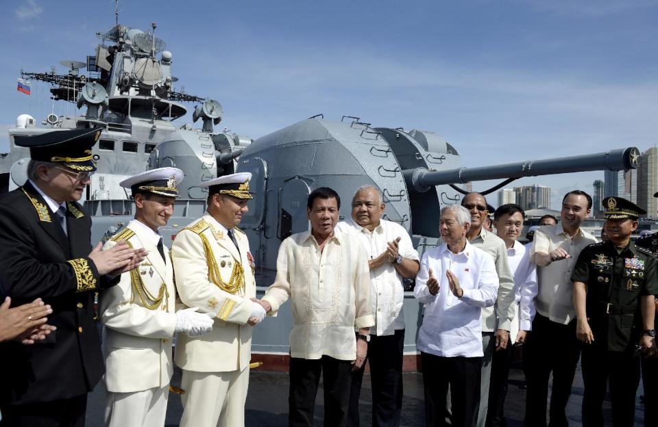 FILE - In this Jan. 6, 2017, file photo, Philippine President Rodrigo Duterte, fourth from left, shakes hands with Russia's Rear Adm. Eduard Mikhailov, third from left, at the anti-submarine navy ship Admiral Tributs at the south pier in Manila, Philippines. A flurry of goodwill visits by ships and submarines has marked the new year in the South China Sea. In the Philippines, two Russian warships docked in Manila for a five-day visit in a showcase by Moscow to demonstrate what it can offer to a traditional U.S. ally. (Noel Celis/Pool Photo via AP, File)