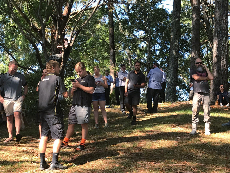 People gather on high ground and check for any sign of a tsunami near Whangarei, New Zealand, Friday, March 5, 2021. A powerful magnitude 8.1 earthquake struck in the ocean off the coast of New Zealand prompting thousands of people to evacuate and triggering tsunami warnings across the South Pacific. (Karena Cooper/New Zealand Herald via AP)